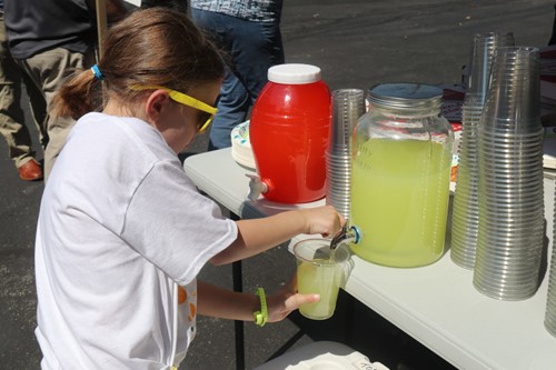 little girl serving lemonade